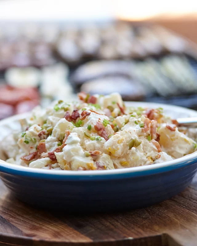 Want to take your potato salad to the next level? We've created our own twist on this classic with the addition of smoked paprika do add more depth of flavour.FULL RECIPE ⬇️INGREDIENTS
200g British Sausage Ham & Bacon Co Traditional Back Bacon, diced
1kg Royal Blue Potatoes, whole and unpeeled
4 hard boiled eggs, slices (save one for serving)Dressing:
½ cup whole-egg mayonnaise
¼ cup sour cream
1 tbsp cider vinegar
1 tbsp water
1 tsp of smoked paprika
1 tbsp of finely chopped gherkins
Salt, pepper for seasoning
2 tbsp chopped chivesMETHOD
1. Place potatoes in large saucepan and cover with water, with ½ teaspoon of salt. Bring to boil, then cook for 10 to 12 minutes, or until tender. Drain and let cool down.2. While potatoes are cooling, heat a large fry pan and add bacon. Cook the bacon on medium heat for 5 minutes or until bacon is deliciously crispy. Turn heat off.3. Peel skins off potatoes, then cut into approximately 2cm x 2cm cubes and place into bowl with 3 of the chopped eggs4. Combine mayonnaise, sour cream, smoked paprika, chopped gherkins and vinegar and mix through the chopped potatoes, egg, most of the chopped chives and most of the diced cooked bacon. Taste and then season with salt and pepper. Toss through to combine all ingredients.5. Place into serving bowl and top with remaining sliced egg, bacon and chopped chives.