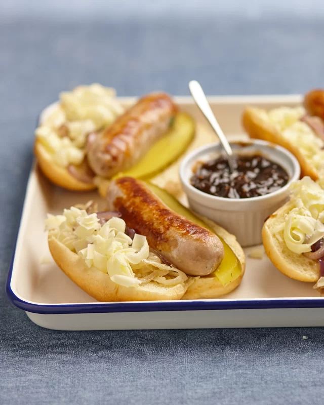 The look of a hotdog with the heart of a Ploughman's - that's what these little beauties have to offer 😍A Cumberland sausage served alongside grated Cheddar, a slice of pickle and a dollup of Branston Pickle... how could you not love that?#cumberland #sausages #branstonpickle #cheddar #fingerfood