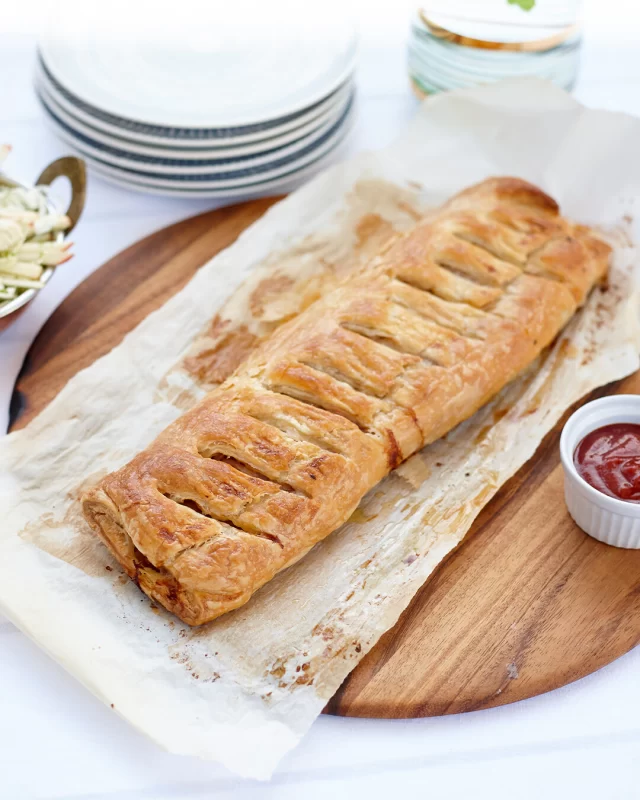 Need a delicious lunch to share with a crowd? Try making this King-Sized Posh Sausage Roll!Full recipe below ⬇️INGREDIENTS
1 onion, finely diced
4 rashers of British Sausage Ham & Bacon Co Traditional Smoked Streaky Bacon, diced
6 British Sausage Co Pork & Apple Sausages
375g all-butter puff pastry (rolled to approx. 25cm x 50cm wide) or use two thawed puff pastry sheets joined together
Egg, beaten (for pastry)METHOD
1. Preheat oven to 220°C (200°C fan-forced).
2. Heat oil in a frying pan over medium heat. Add the onion and bacon. Cook until the onion is soft, and the bacon is nicely browned. Set aside to cool slightly.
3. Remove the skins from the sausages and place the sausage meat into a large bowl.
4. Add the cooled onion and bacon mixture to the sausage meat and mix well to combine.
5. Lay out the puff pastry on a clean surface. Spoon the sausage mixture in a long, even line down the centre of the pastry.
6. Fold the pastry over the filling to enclose, pressing the edges together to seal. Use a fork to crimp the seam if desired.
7. Place seam-side up (for a rustic look) on a lined baking tray. Brush the top with a beaten egg. Then, using a sharp knife, make a few diagonal slits across the top to allow steam to escape during baking.
8. Bake for 30–35 minutes or until the pastry is golden and puffed, and the filling is cooked through.
9. Rest for 5 minutes before slicing. Serve warm or at room temperature.#sausagerollrecipe #giantsausageroll #sausagerecipes #sausageroll #familymealideas