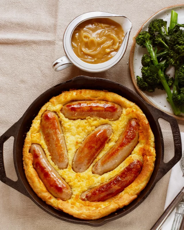 It's nearly that time of year again...colder, darker, cozier...perfect for a classic toad in the hole cookup!FULL RECIPE BELOW ⬇️INGREDIENTS
Using The British Sausage Co. Cumberland Sausages or The British Sausage Co. Beef Eater SausagesYorkshire Pudding Batter
4 large eggs
1 cup of plain flour
¾ cup full cream milk
¼ cup of water
½ teaspoon salt
2 tablespoons beef dripping or oil of your choice that can handle high heat.METHOD
1. Make the batter first. Whisk eggs in a bowl then add in the sifted flour and salt. Mix the eggs and flour well then gradually whisk in milk and water to the mixture to create a smooth batter with no lumps. Transfer to the fridge and let rest. You want the batter nice and chilled.
2. While the batter is resting, in a moderate oven, (approximately 160OC) heat 1 tablespoon of the beef dripping in a roasting pan and add the sausages. Cook for 7 to 10 minutes ‘til the sausages are a light golden. You don’t want them fully cooked yet as they will finish cooking in step 4.
3. Remove the sausages from the roasting pan and let sit on a plate. Next, add the remaining 1 tablespoon of beef dripping to the pan and return to a very hot oven (approximately 220OC) for 5 to 10 minutes to get the dripping very hot… this is the secret to the fluffy pudding.
4. Next, very carefully (it will be hot!) remove roasting pan from the oven and add sausages back to the roasting pan, allowing space around each. Finish by carefully pouring the batter around the sausages and the bake in the very hot oven for 20 minutes or until puffed and golden.
5. Serve with your favourite veg and onion gravy.#winterissausageseason #toadinthehole #britishfood #dinnerideas #sausagerecipes